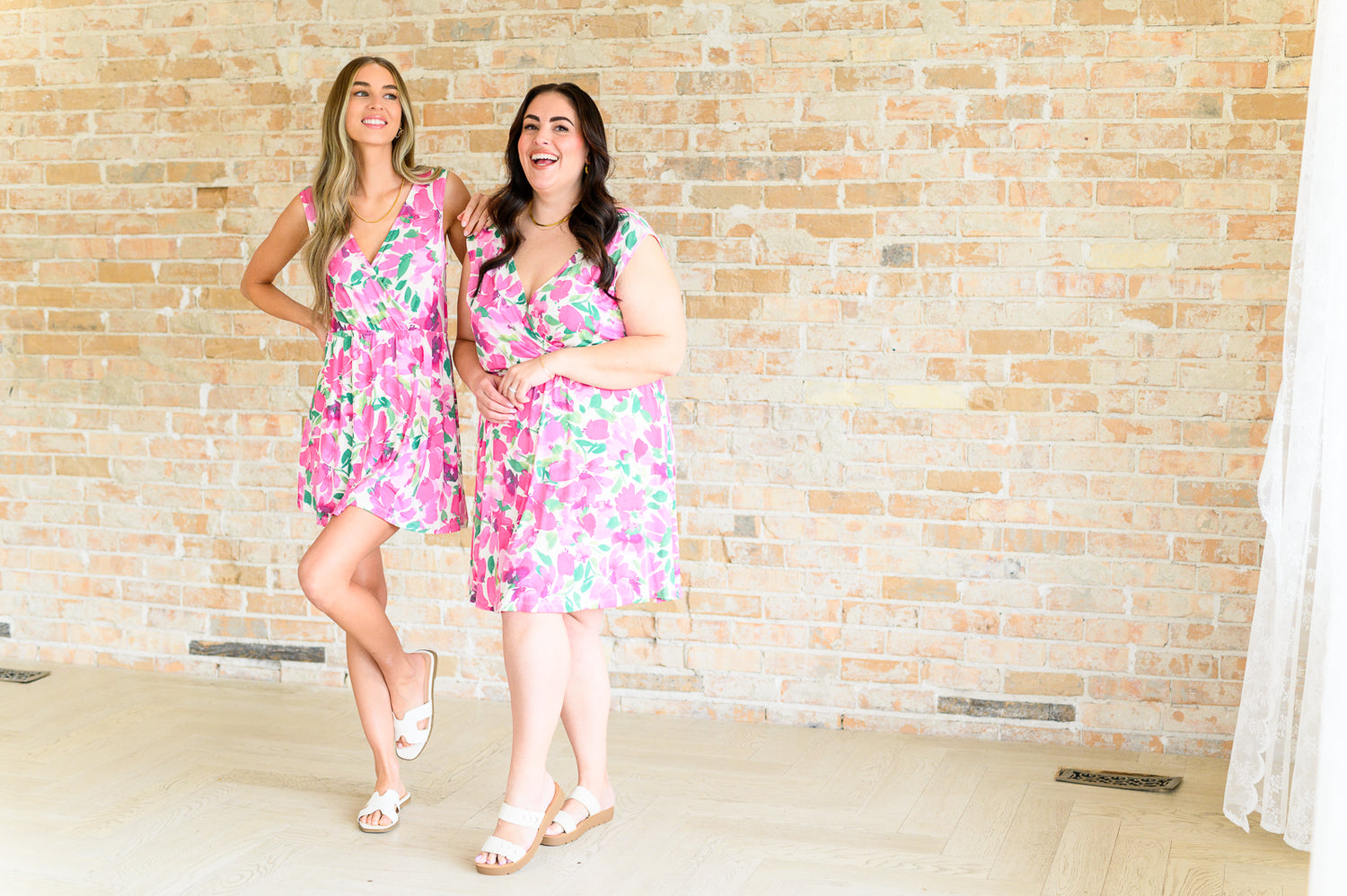 two models in matching pink floral dresses